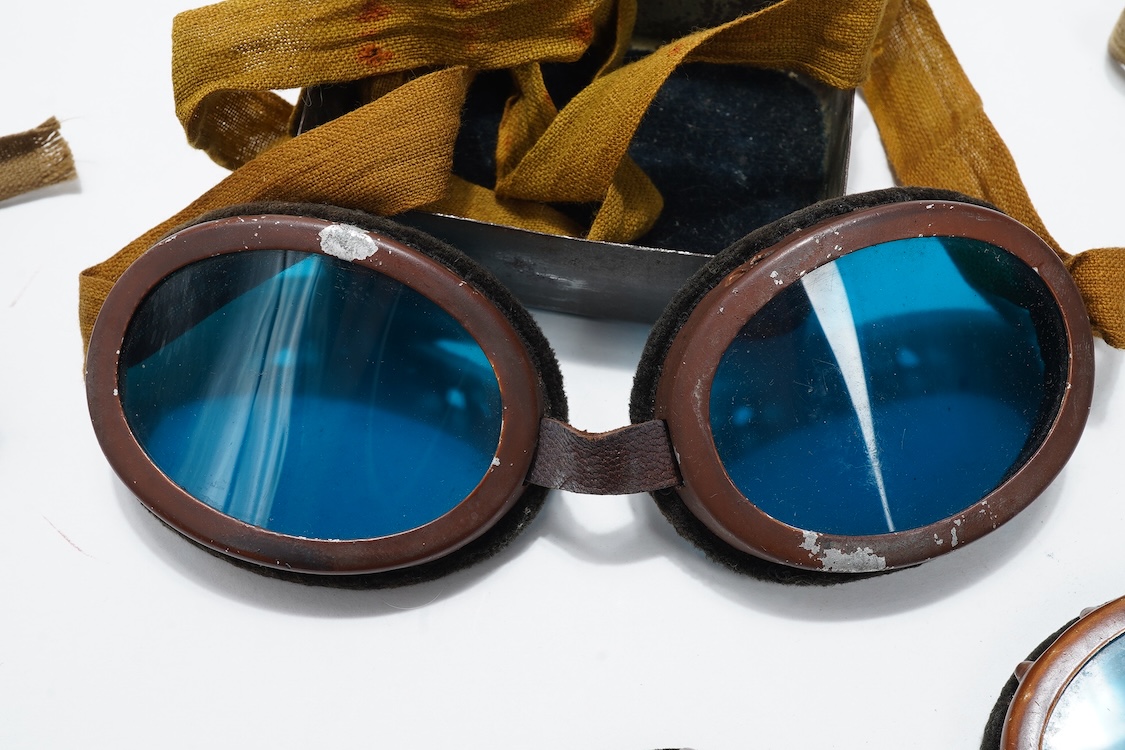 Two pairs of WW2 desert goggles, blue tinted lenses, one with original tin box